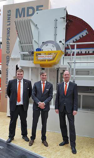 Алекс Хекманн и Александр Гебеле (Holtec), Карл Йозеф Эрлих (NYBLAD) на фоне дисковой рубительной машины для производства щепы для MDF 