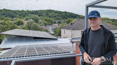 Директор Brutăria Bardar Виктор Нисторика позирует на фоне солнечных панелей, обеспечивающих энергией его предприятие